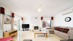 A spacious living room with a flat-screen TV, a fireplace, a sofa, and a coffee table. - Modern villa near beach [83] (Lagos)