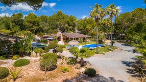 Ein Resort mit Pool, Palmen und einem Steinhaus.