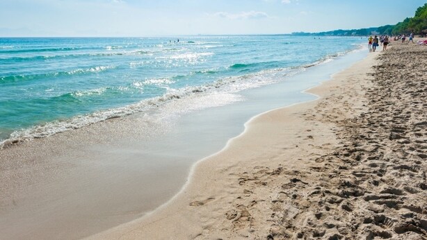 A beach with clear blue water, sandy shore, and people walking. - CAN GARRETA - Beautiful holiday home near the beach. Free WiFi (Alcúdia)