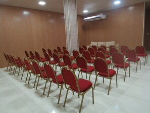 A conference room with rows of red chairs and a white ceiling. - Farol Plaza Hotel (Aracaju)