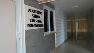 Un pasillo con un cartel que dice 'AUDITÓRIO SÓNIA CRISTINA IROLEMBERG' en la pared.