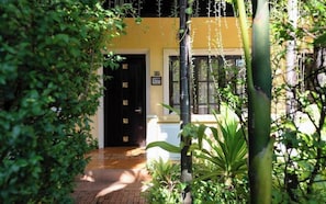 Um edifício com fachada amarela, porta preta e janela com o número 105.