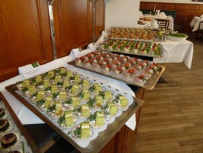 A buffet table with various food items, including appetizers and desserts, in a hotel setting. - Hotel Exel (Amstetten)