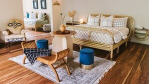 Ein gemütliches Schlafzimmer mit einem Bett, einem Sessel, einem Tisch und einem kleinen Beistelltisch.
