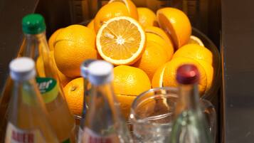 Un lavabo con un bol de naranjas y botellas.