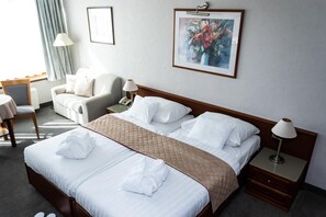 A hotel room with a large bed, two bedside tables, a desk, a chair, and a window with curtains. - Rosengarten Hotel Restaurant (Sopron)