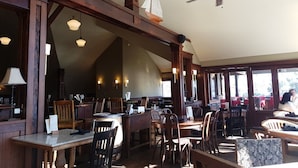 Un restaurant avec des poutres en bois, une décoration sur le thème de la voile et un ventilateur de plafond.