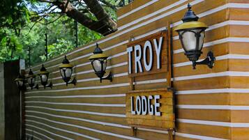 A wooden fence with the words "TROY LODGE" and decorative street lamps.