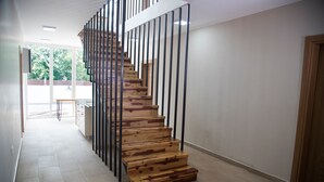 A modern staircase with wooden steps and black metal railings, leading to an upper floor. - Troy Serviced Apartments (Lusaka)