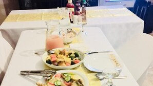A dining table set with various dishes, including rice, vegetables, and meat, along with condiments and cutlery. - Carnival View Guest house (Boksburg)