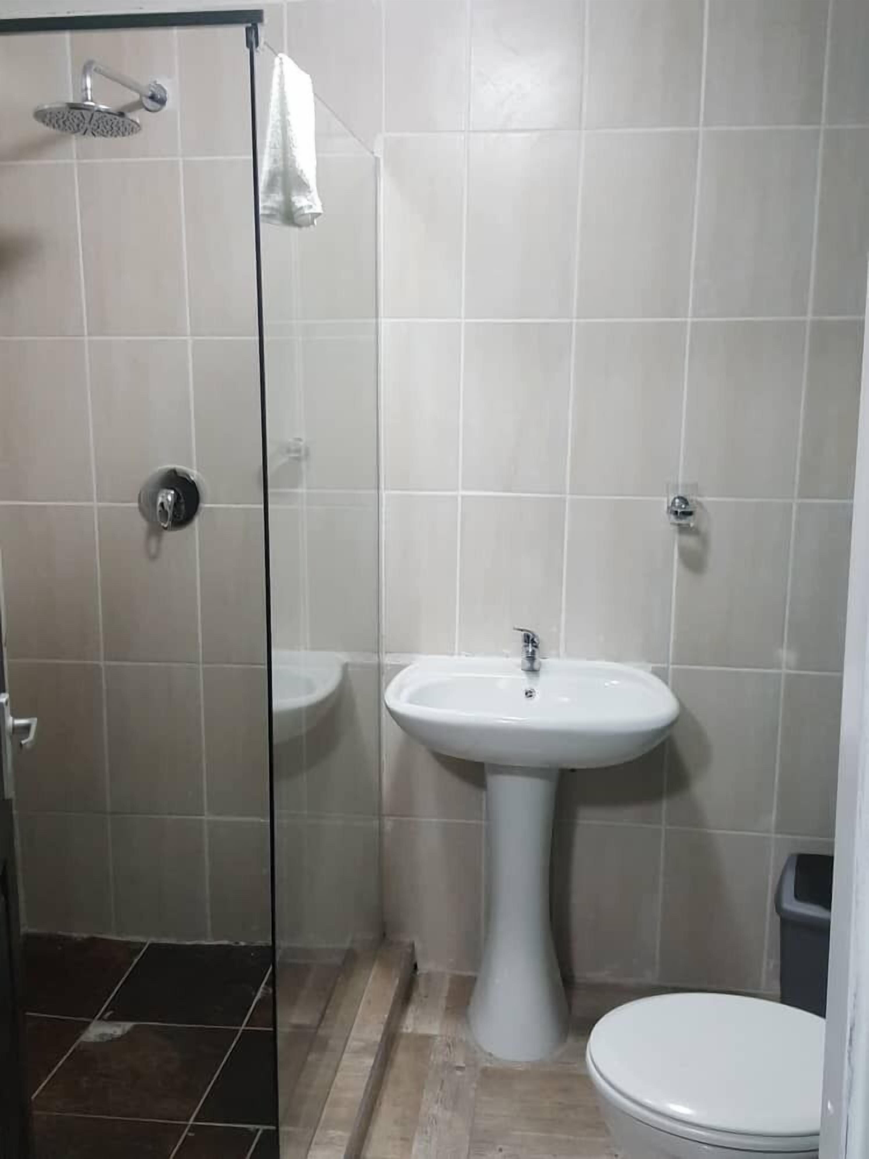 Ein Badezimmer mit Dusche, Waschbecken und Toilette.