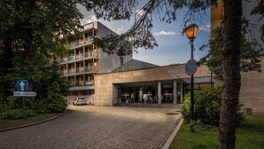 Un edificio de estilo arquitectónico moderno, con entrada de adoquines y una señal que indica una dirección.
