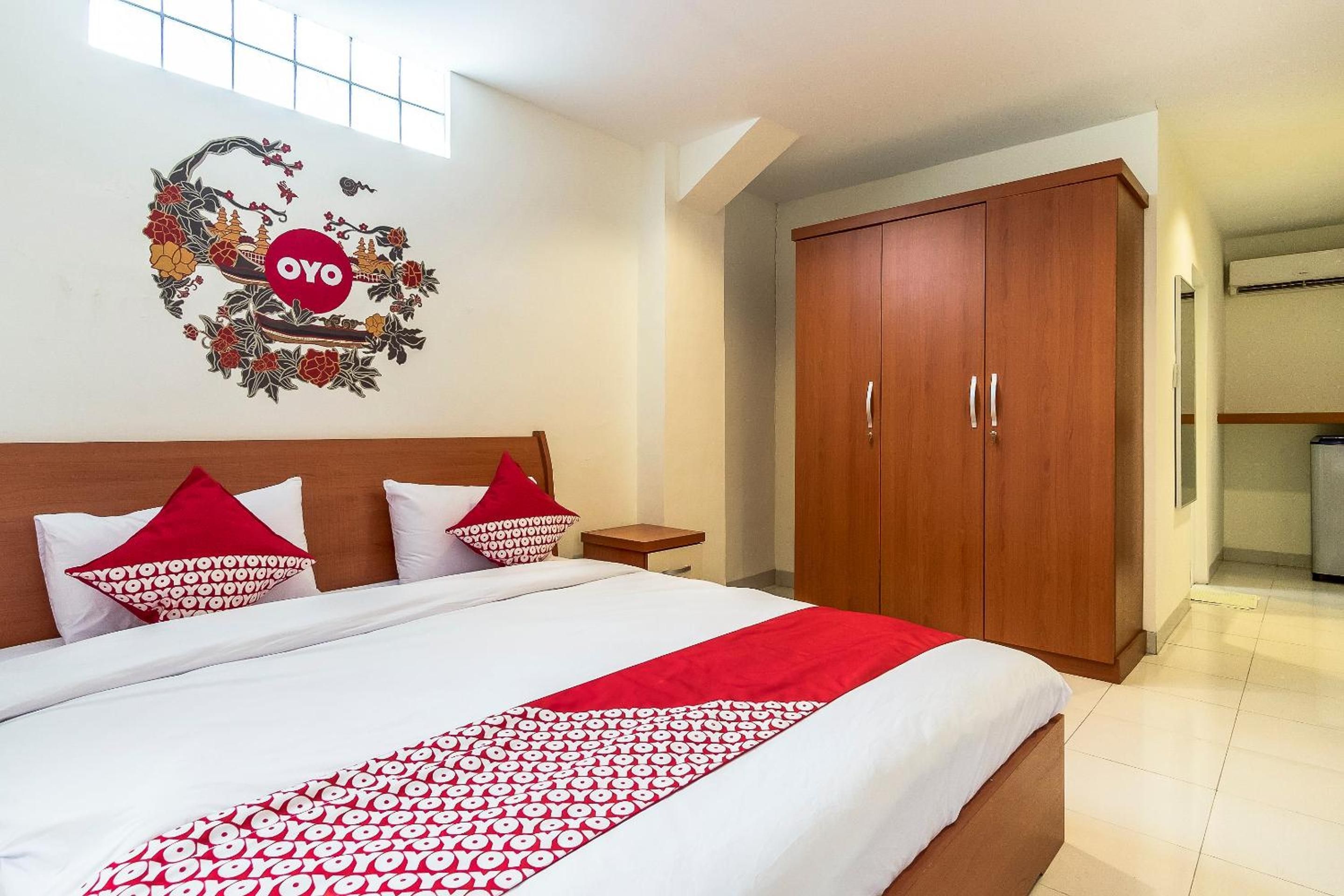 Ein Hotelzimmer mit einem Bett, einem Kleiderschrank und einer Wanddekoration.