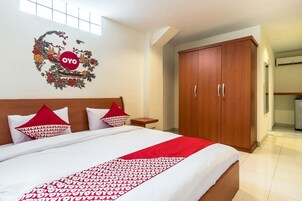 Una habitación de hotel con una cama, un armario y un adorno en la pared.