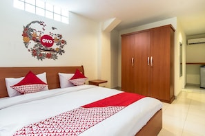 A hotel room with a bed, a wardrobe, and a wall decoration.