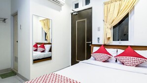 A hotel room with a bed, a wardrobe, a mirror, and a window with curtains. - Stadthotel Gürtler (Amstetten)