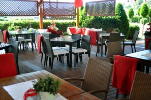 An outdoor dining area with wicker furniture, tables, and chairs. - Ahotel (Czechowice-Dziedzice)