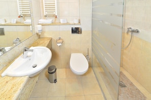 A bathroom with a sink, toilet, and shower.