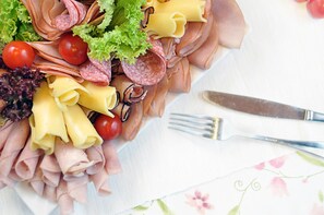 A platter of assorted deli items including meats, cheeses, and vegetables. - Ahotel (Czechowice-Dziedzice)