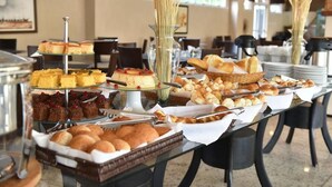 Una mesa de buffet con diversas opciones de panadería y pastelería.