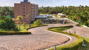 Un hotel con edificio de ladrillo, jardines ajardinados y una entrada de carril curva.