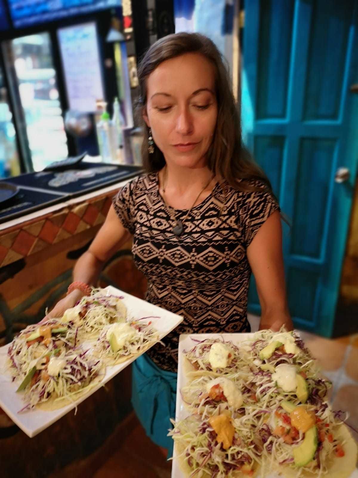 Une personne tenant deux assiettes de nourriture.