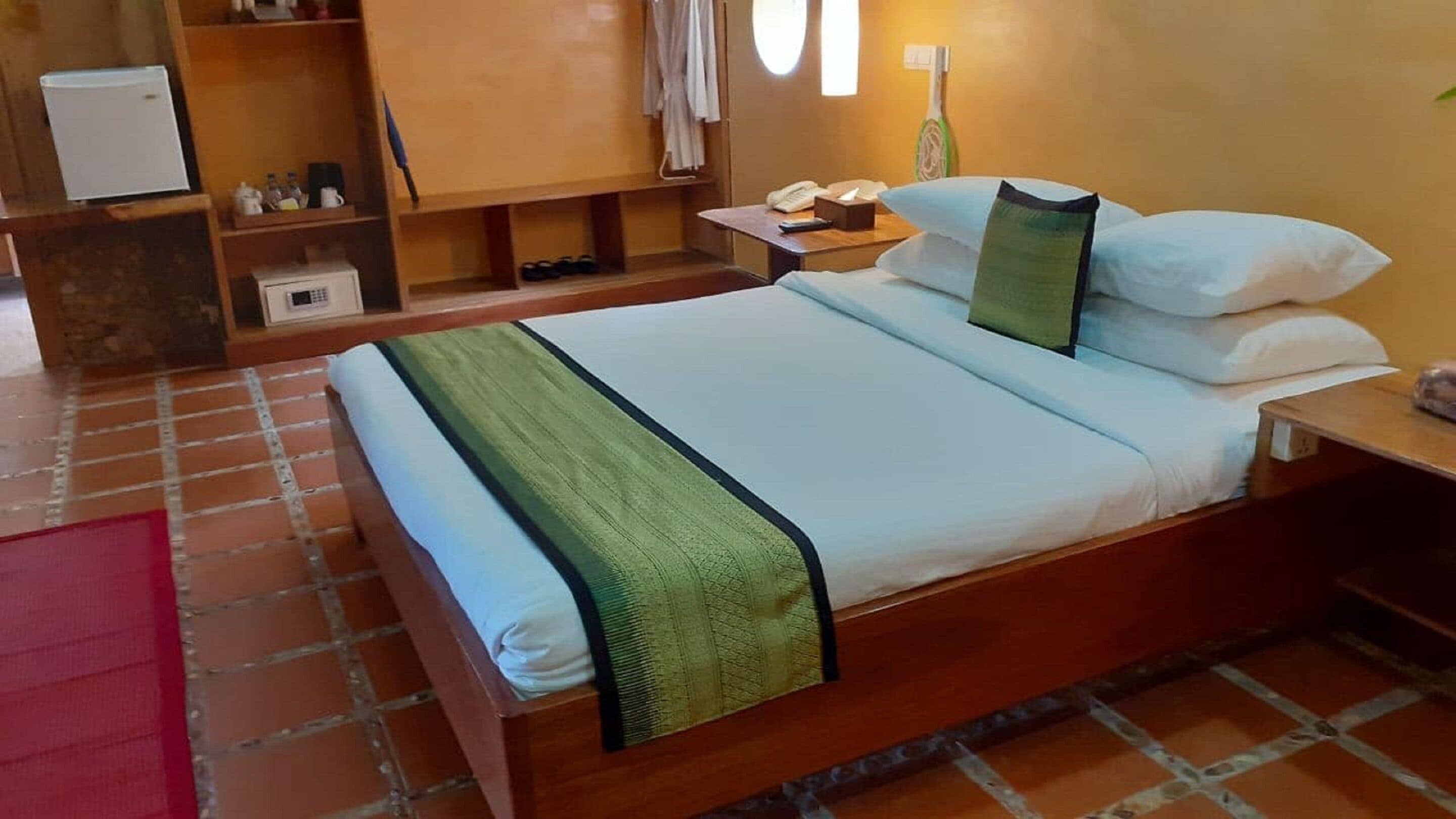 Habitación de hotel con cama, mesita de noche, escritorio, armario y baño.