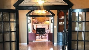 A spacious living area with a fireplace, comfortable seating, and a polished floor.