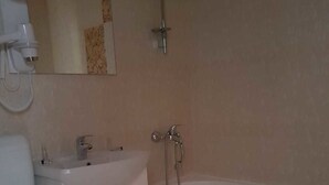 Une salle de bain avec des toilettes, un lavabo et une baignoire.