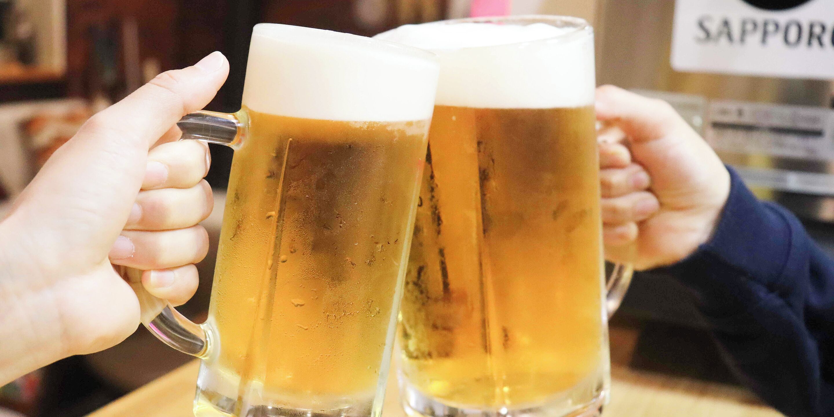 Two people holding up beer mugs.