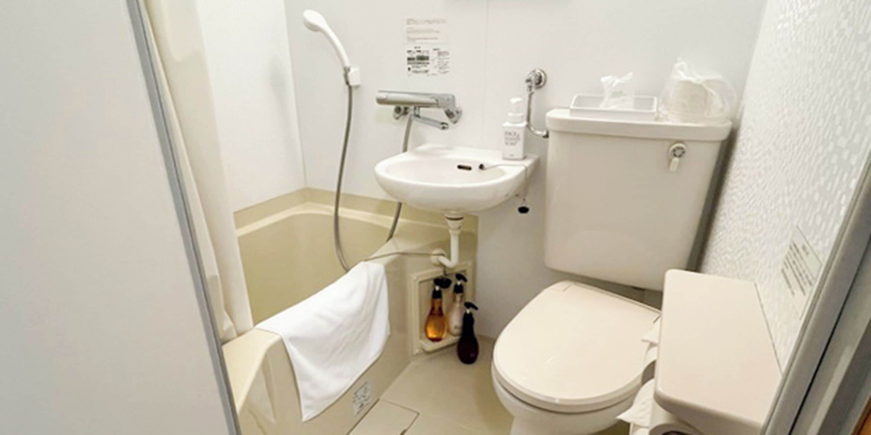 Un baño pequeño con inodoro, lavabo y ducha.