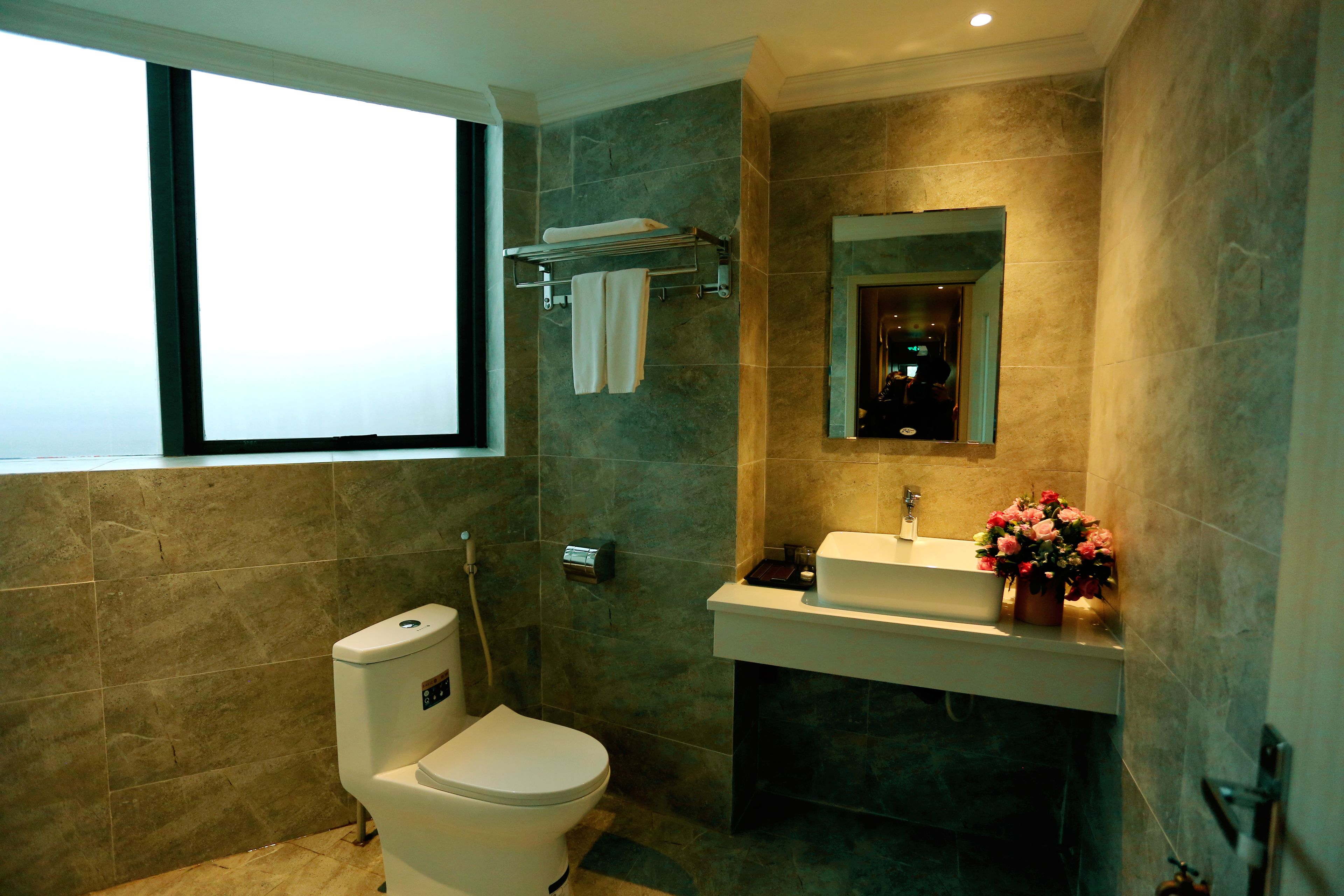 A modern bathroom with a toilet, sink, and mirror.