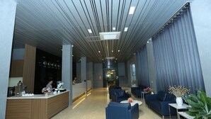 A modern hotel lobby with a reception desk, seating area, and a staircase leading to the upper floors. - Korinn Pho Yen Hotel (Van Xuan)
