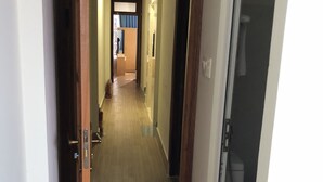 A hallway with wooden flooring, a tiled entrance, and a door leading to a bathroom. - Van Minh Hotel (Xuan Huong - Da Lat)