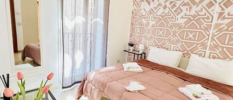 Une chambre d’hôtel comprenant un lit, un bureau avec une chaise, une télévision et un mur décoratif.