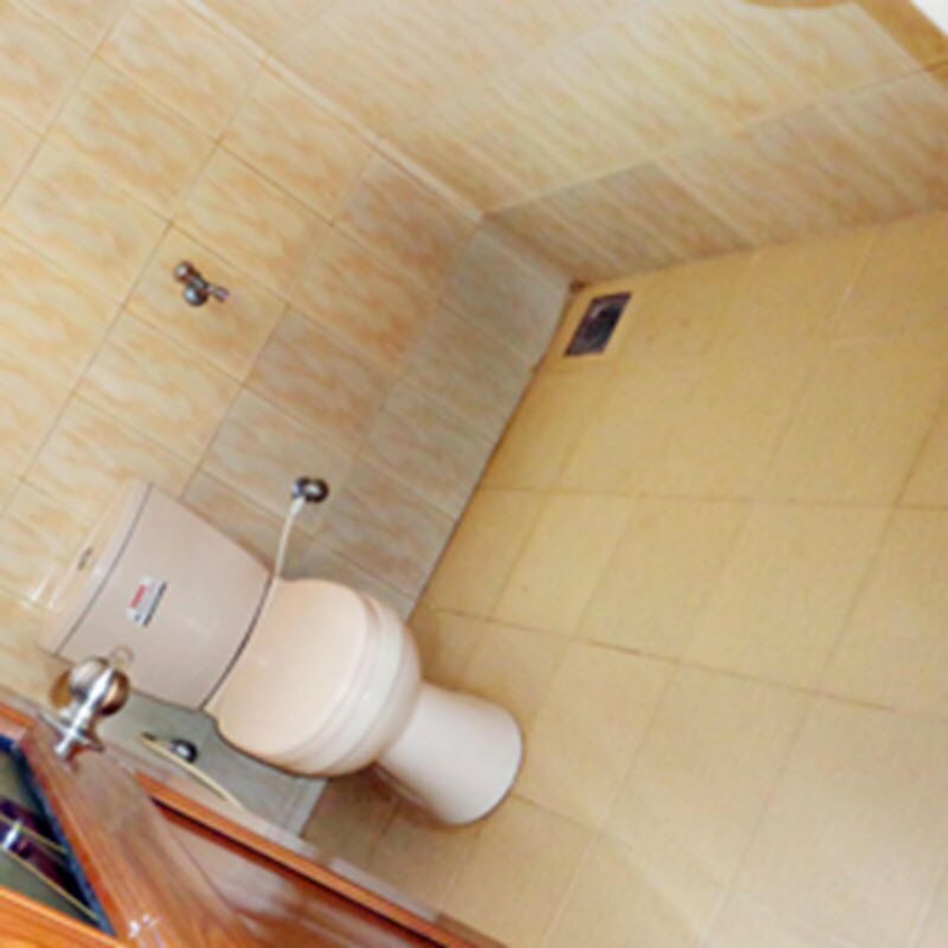 Un baño con inodoro, lavabo y espejo.