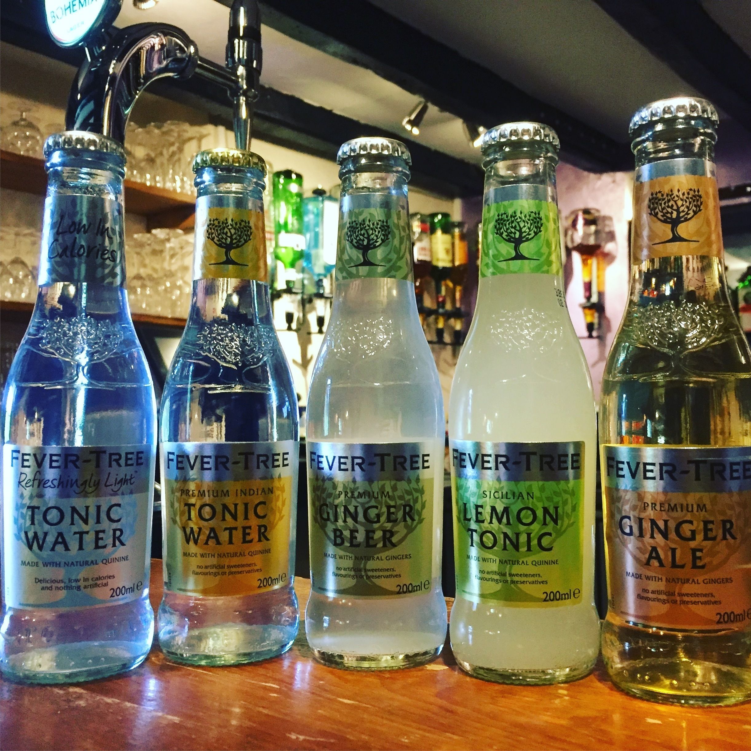 Variedad de bebidas Fever-Tree, que incluyen agua tónica, agua tónica, cerveza de jengibre, tónica de limón y gaseosa de jengibre, cada una con su volumen indicado y lista de ingredientes naturales.