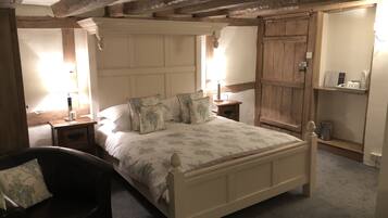 Un dormitorio con cama de madera, una mesita de noche, una silla y un armario.