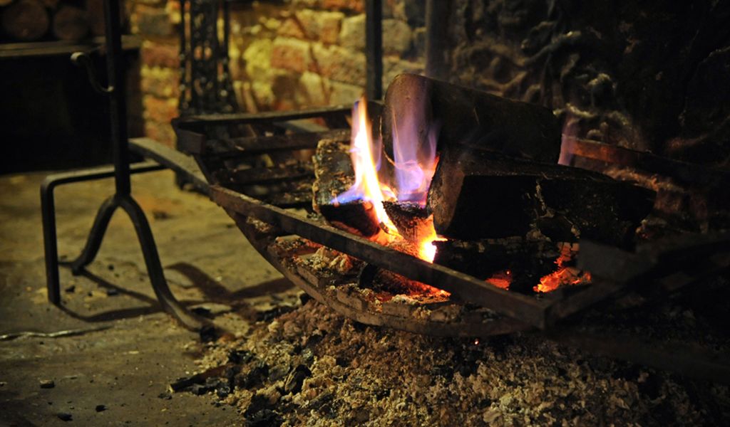 Una chimenea con leña ardiendo y llamas.