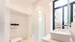A modern bathroom with a large window, a white sink, and a built-in heater. - HD Acuario Lifestyle (Las Palmas de Gran Canaria)