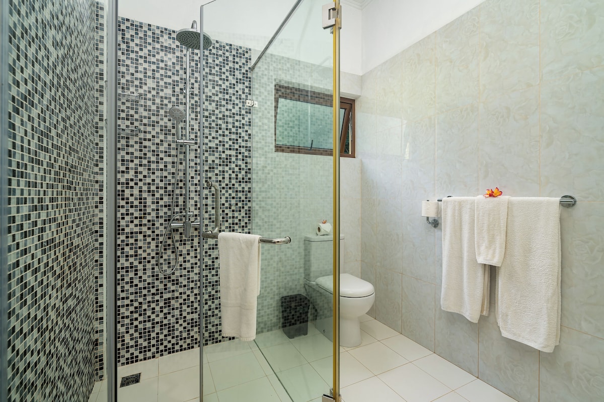 Ein Badezimmer mit Duschkabine, Toilette und Waschbecken.