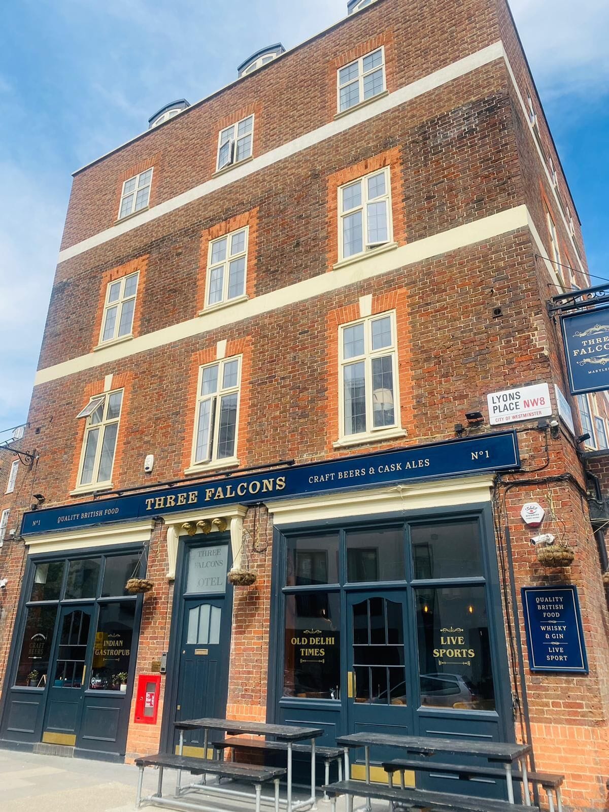 A brick building with a sign for 'Three Falcons' indicating it is a pub.