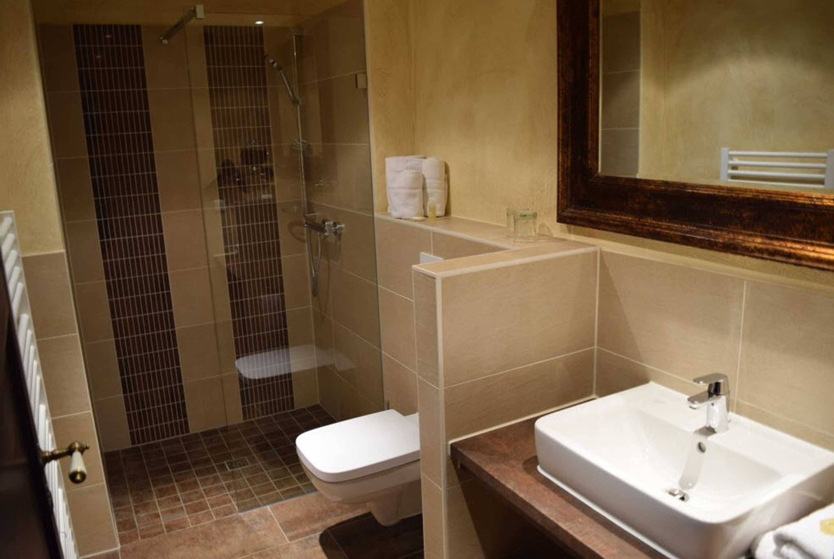 A bathroom with a shower, toilet, and sink.