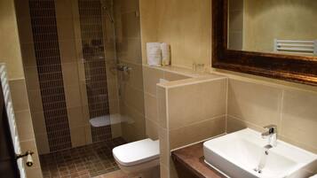 A bathroom with a shower, toilet, and sink.