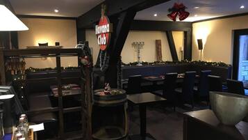 Interior de un restaurante con un letrero de 'Havana Club', barra de madera y decoración navideña.