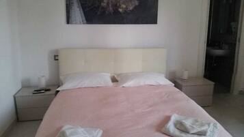 Una camera da letto con un letto, due comodini e un quadro appeso al muro.
