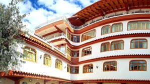 A multi-story building with balconies, arched windows, and a courtyard with outdoor seating.