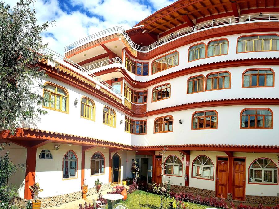 A multi-story building with balconies, arched windows, and a courtyard with outdoor seating.