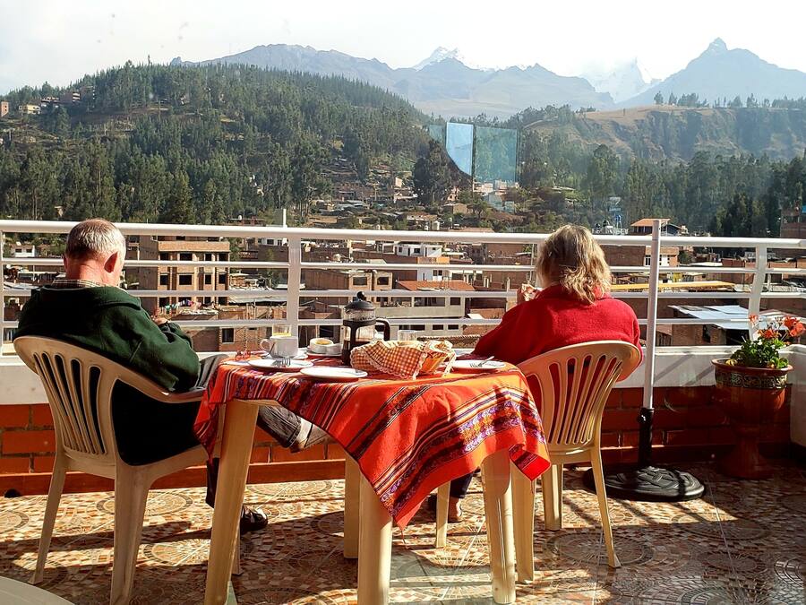 Two people seated at a table with a view of a mountainous landscape.