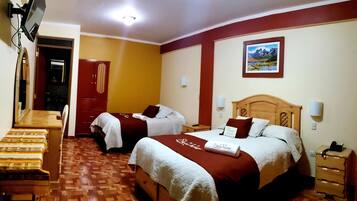 Habitación de hotel con dos camas, un escritorio, un espejo y un televisor.